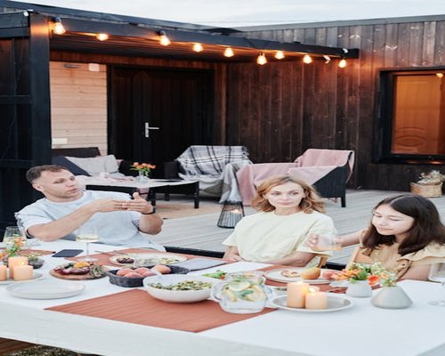 Family having a relaxed dinner together outdoors in a warm setting